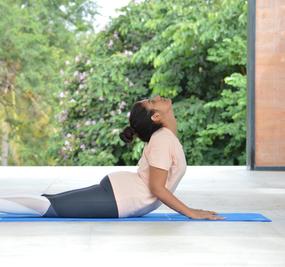 Yoga - lying on the floor on tummy with shoulder and neck stretched upwards in cobra pose