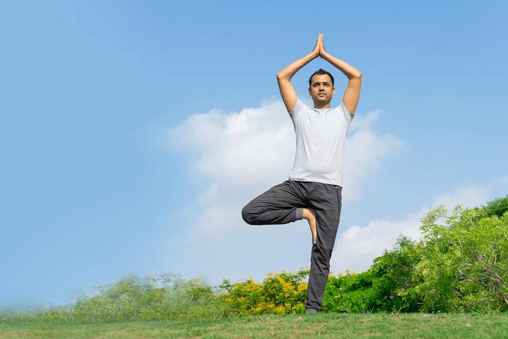 Boy-is-doing-tree-pose-in-a-garden