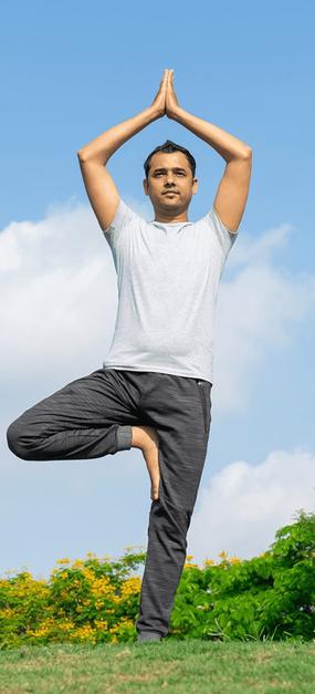 Boy-is-doing-tree-pose-in-a-garden