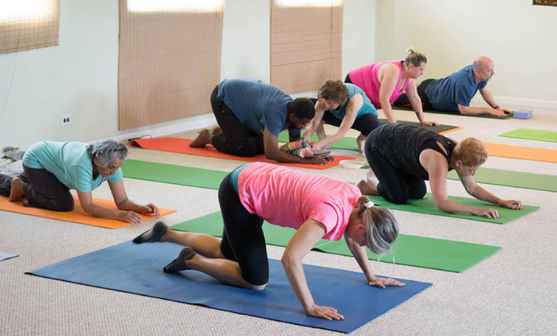 yoga teacher correcting qualities of a good yoga teacher